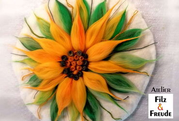 Motiv einer Sonnenblume aus Wolle.